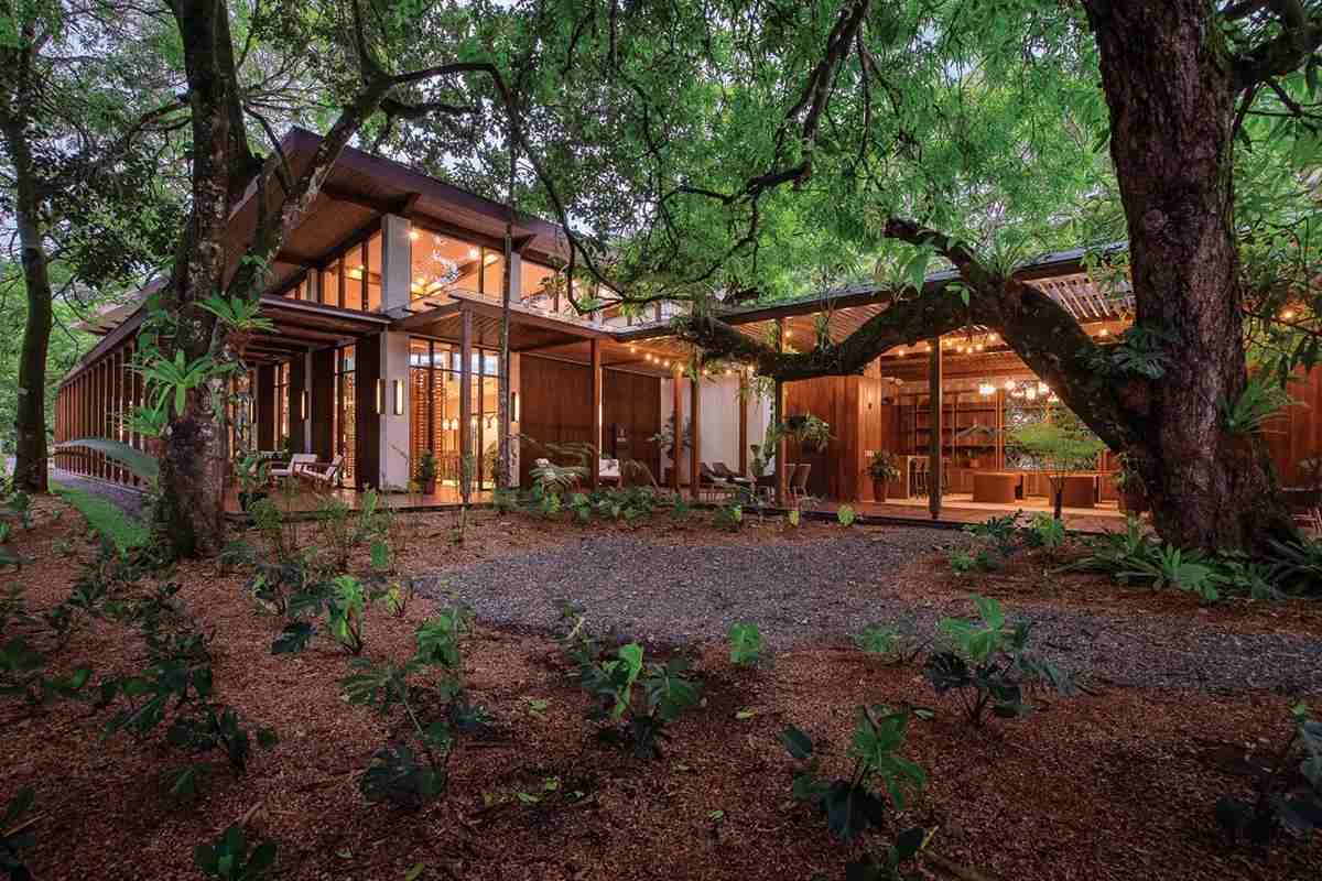 A multi-story wooded lodge in a dense forest. 