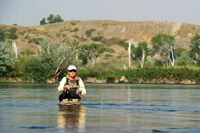 A fly angler watching her drift on Montana's Bighorn River.