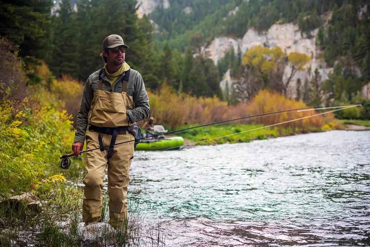 A fly angler wading along the edge of a river in Skwala waders. 