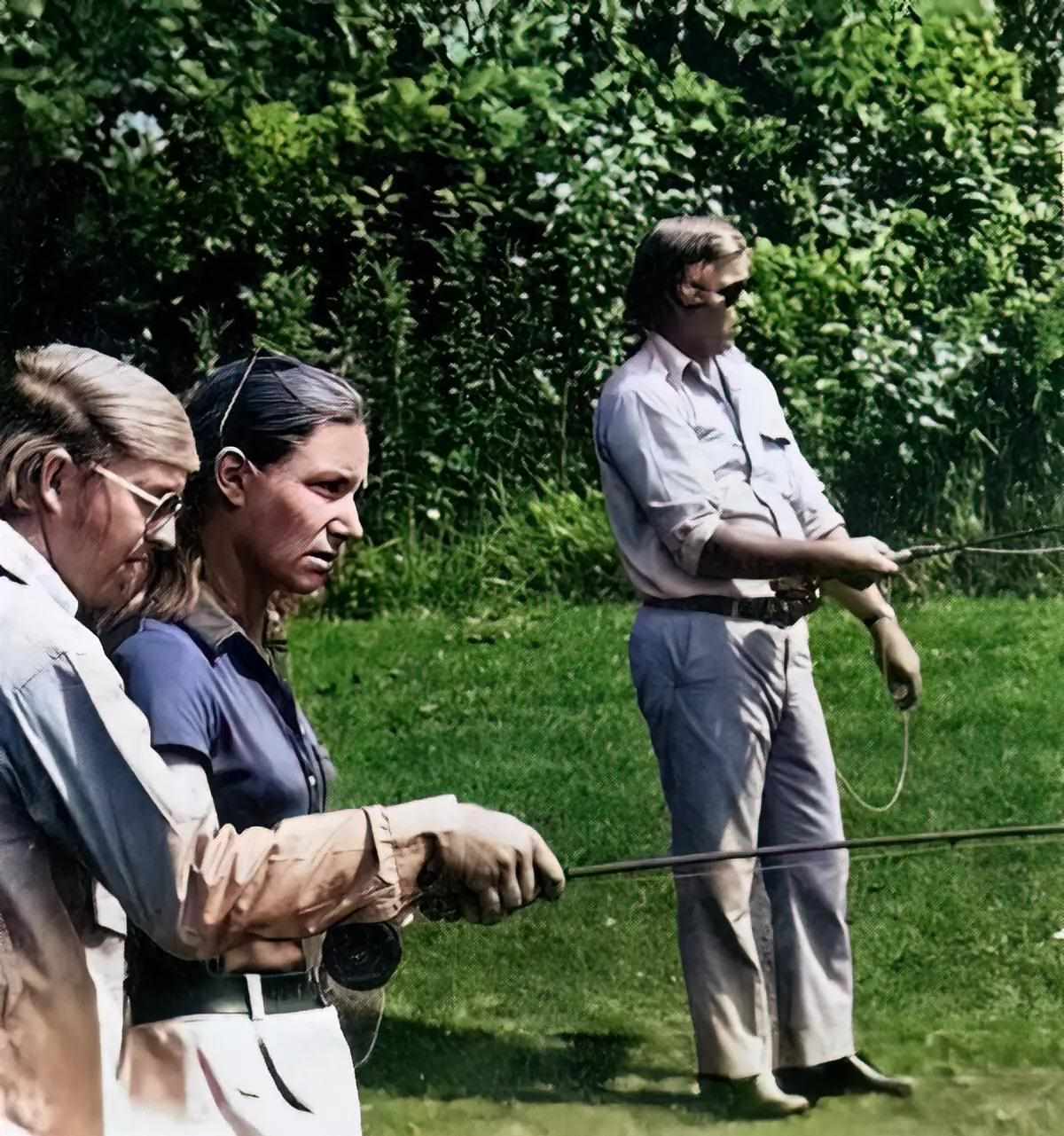 Three fly anglers practice casting on a lawn.