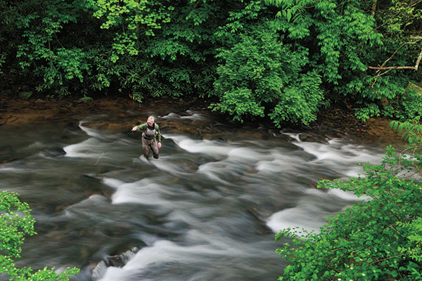 A fly angler nymph fishing on a swift stream.