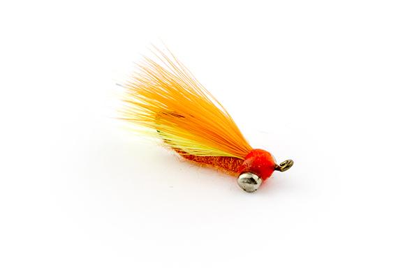 An orange fly tied hook-side up with a large dumbell head.
